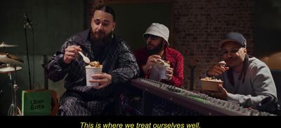 a group of men sitting next to each other eating food