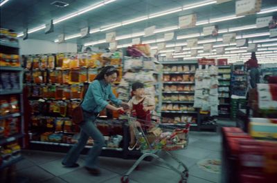 a woman pushing a shopping cart in a store