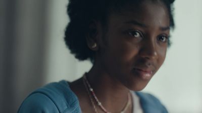 a woman in a blue sweater looking at the camera