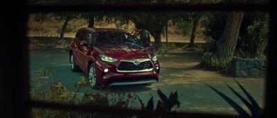 a red suv parked in a driveway next to trees