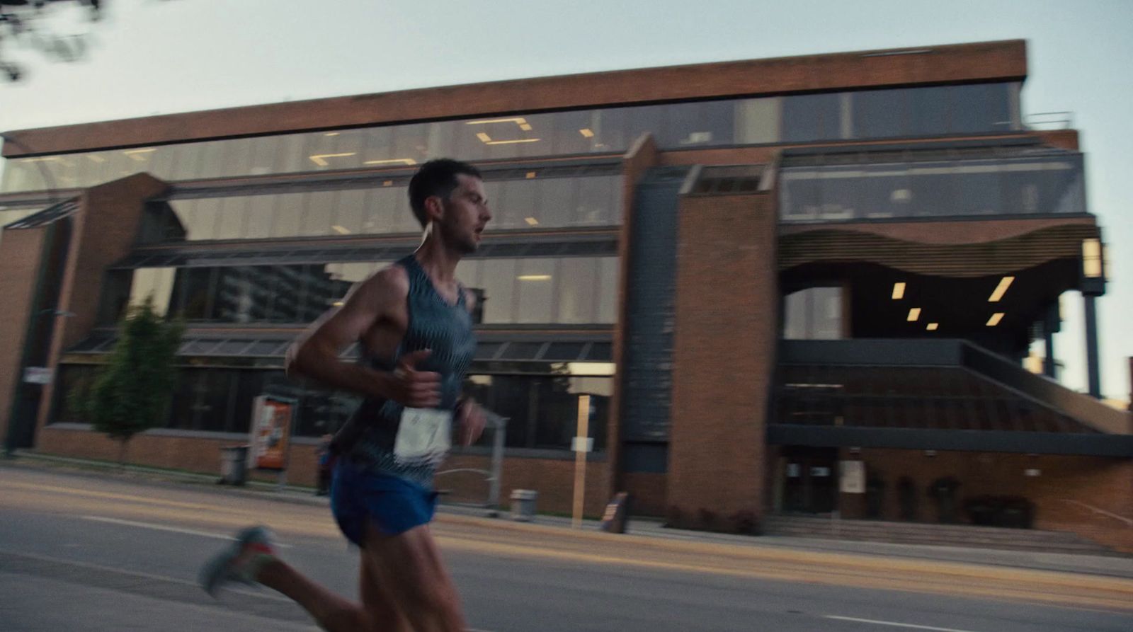 a man running down a street in front of a building