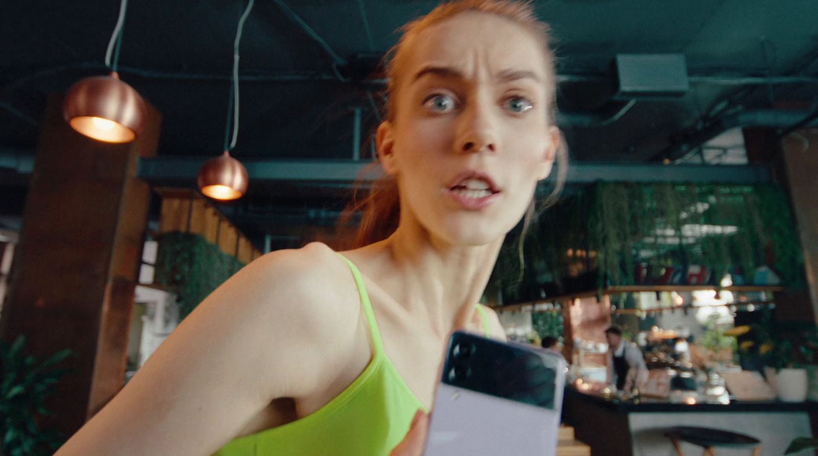 a woman in a green top holding a cell phone