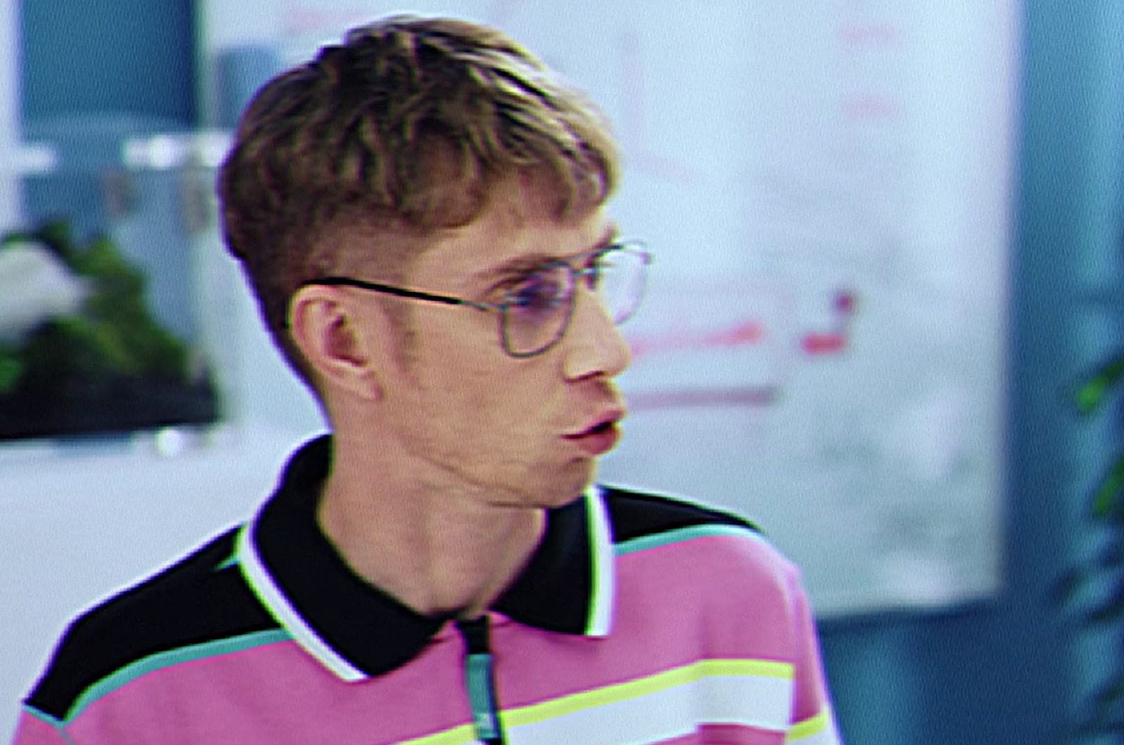 a man wearing glasses and a polo shirt