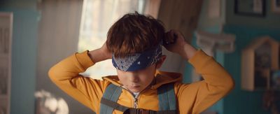 a young boy with a blindfold on his head