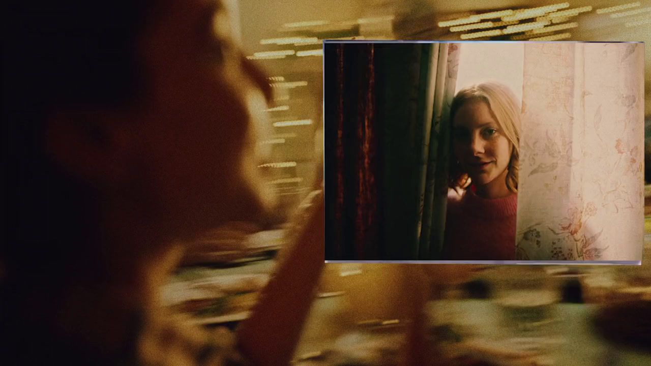 a woman looking at a picture of herself in a mirror