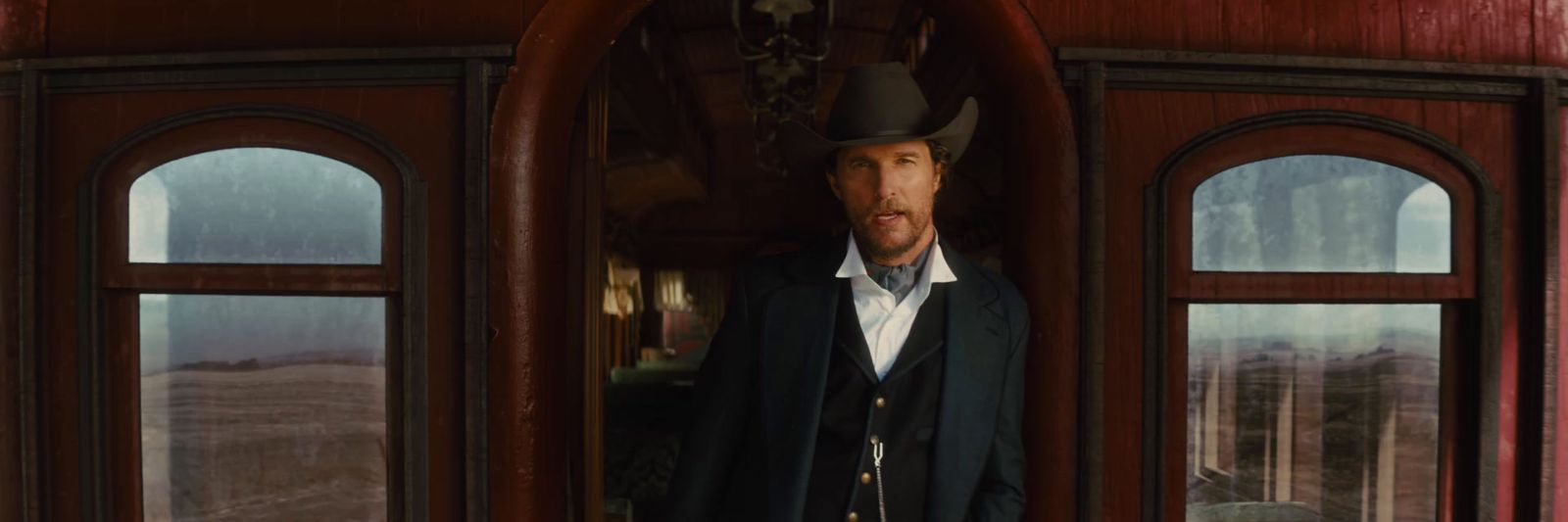 a man in a cowboy hat standing in a doorway