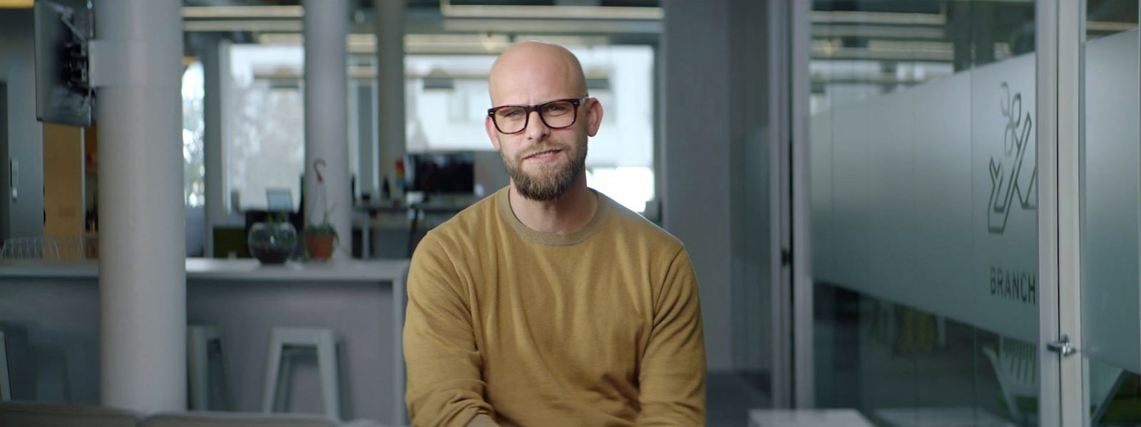 a man with a bald head wearing glasses