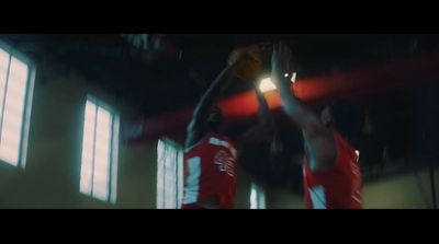 a couple of men standing next to each other on a basketball court