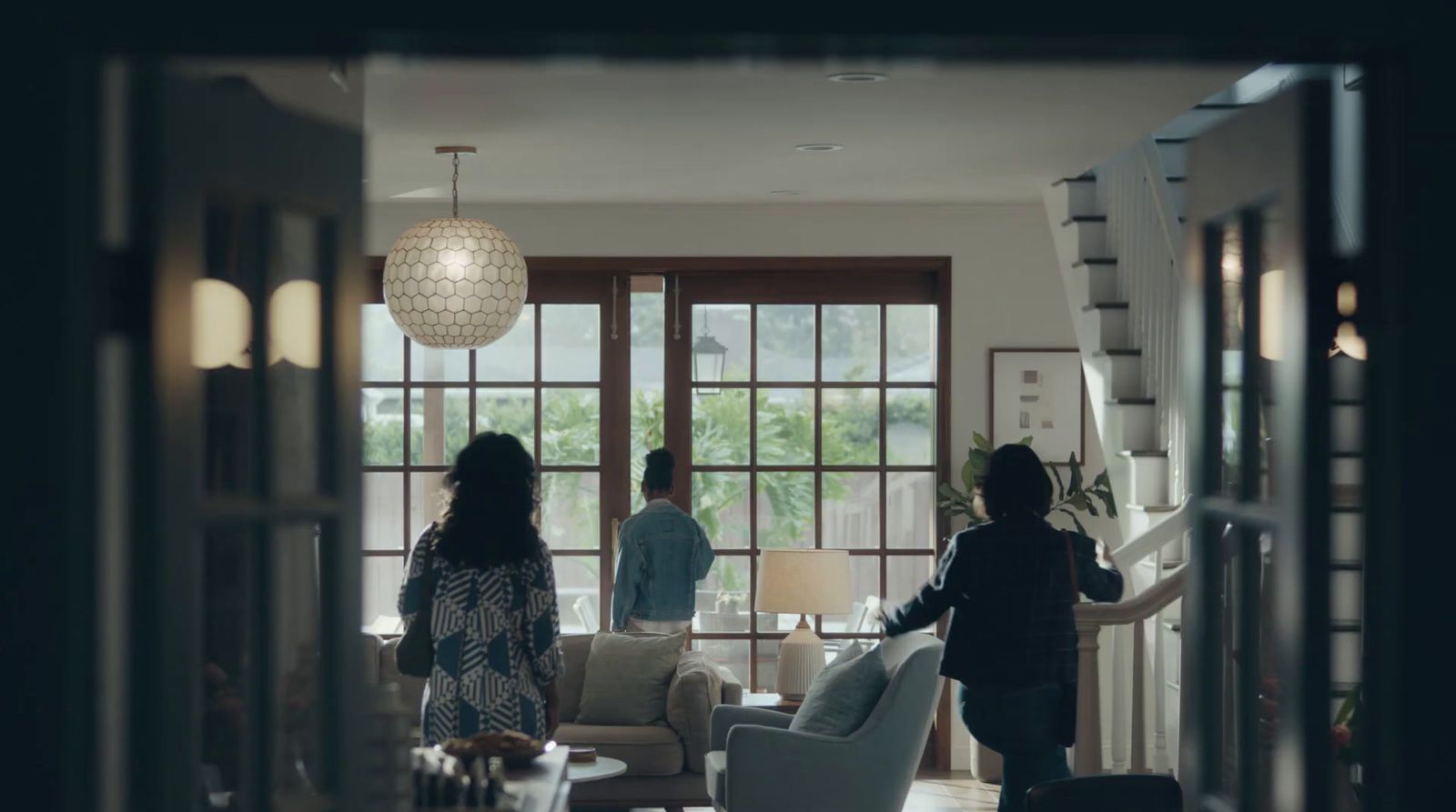 a group of people standing around a living room