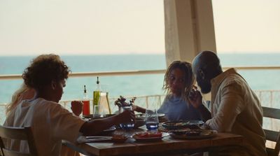 a group of people sitting at a table with plates of food