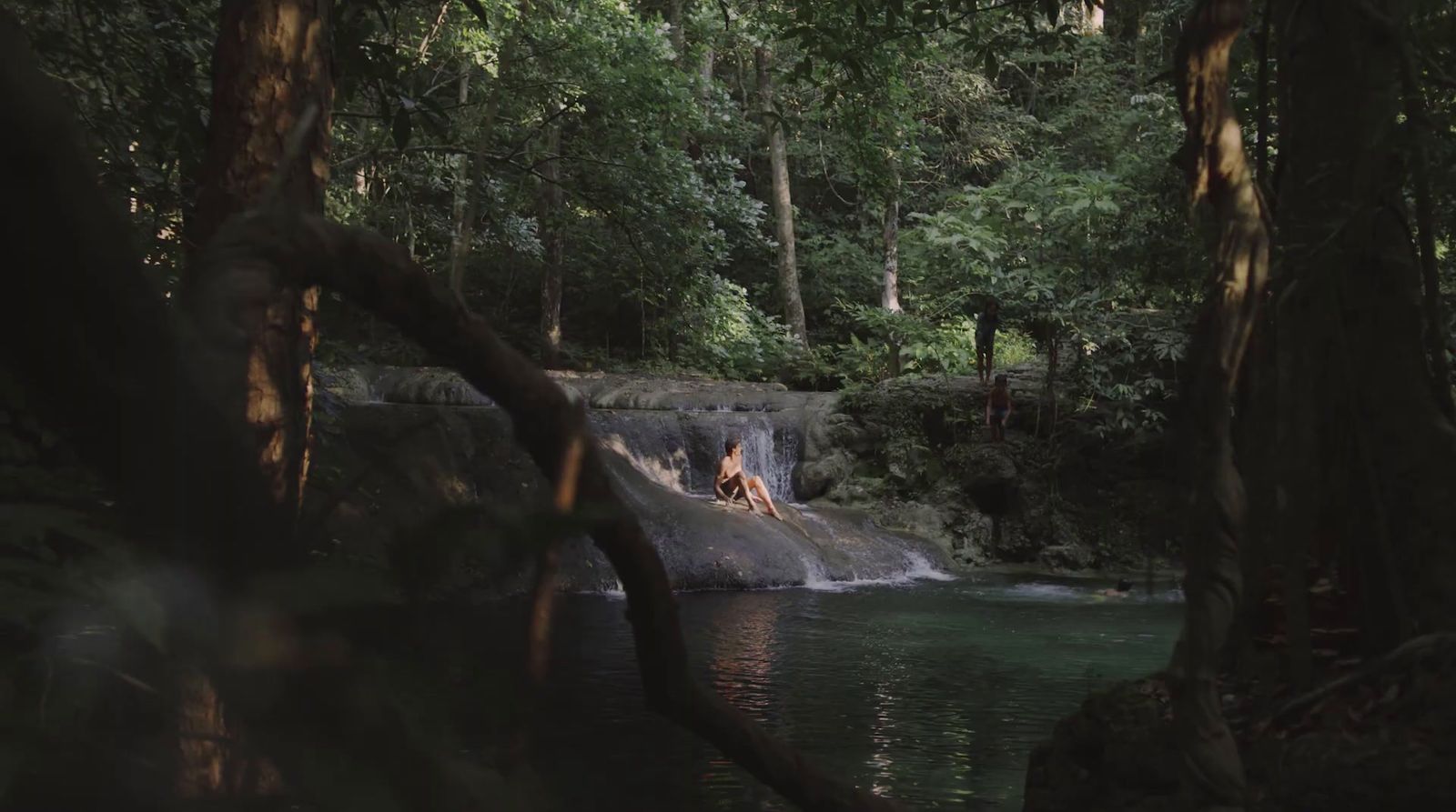 a man standing on a rock in the middle of a river