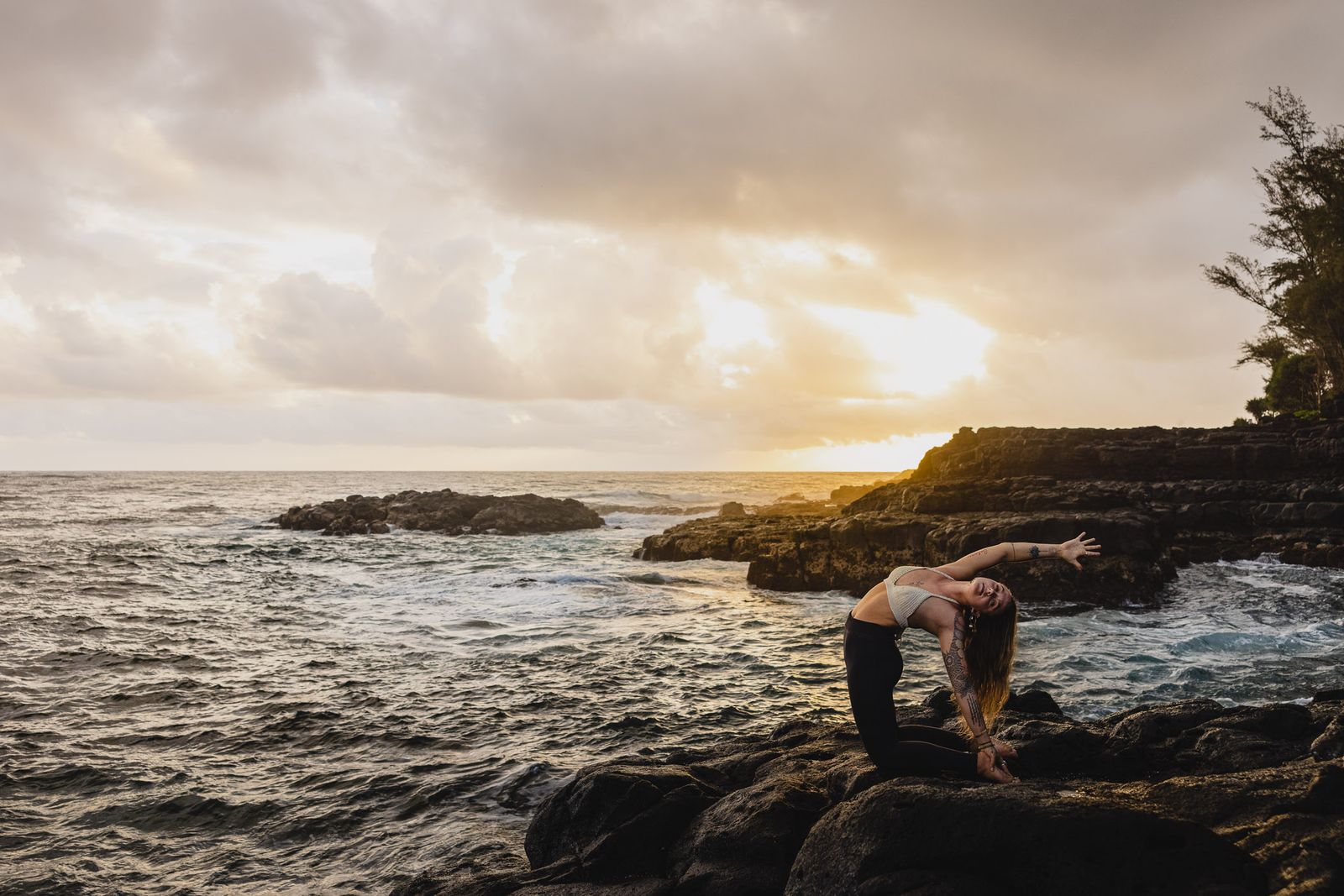 a woman doing a handstand on a rock near the ocean