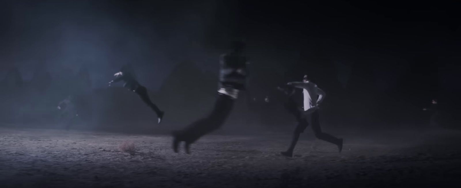 a group of people standing on top of a dirt field