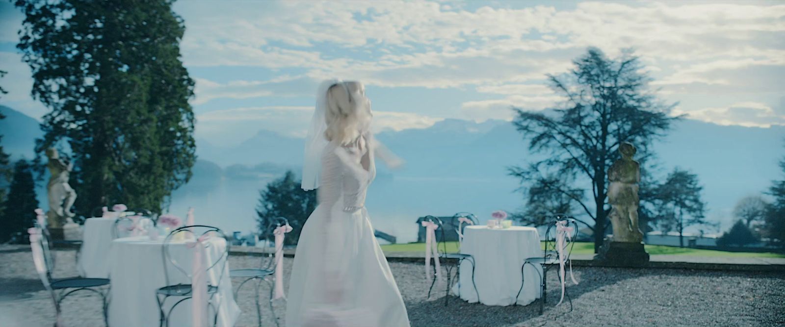 a woman in a white dress standing in front of a table