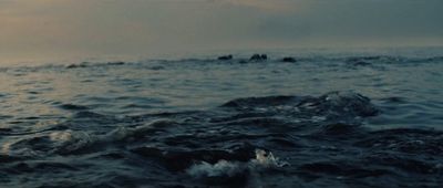 a group of people riding on the back of a boat in the ocean