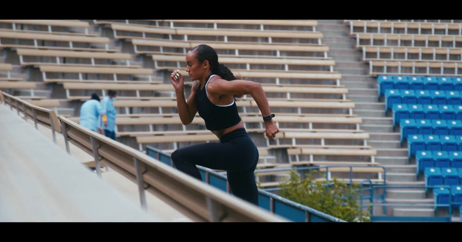 a woman in a black sports bra top and black leggings running up a