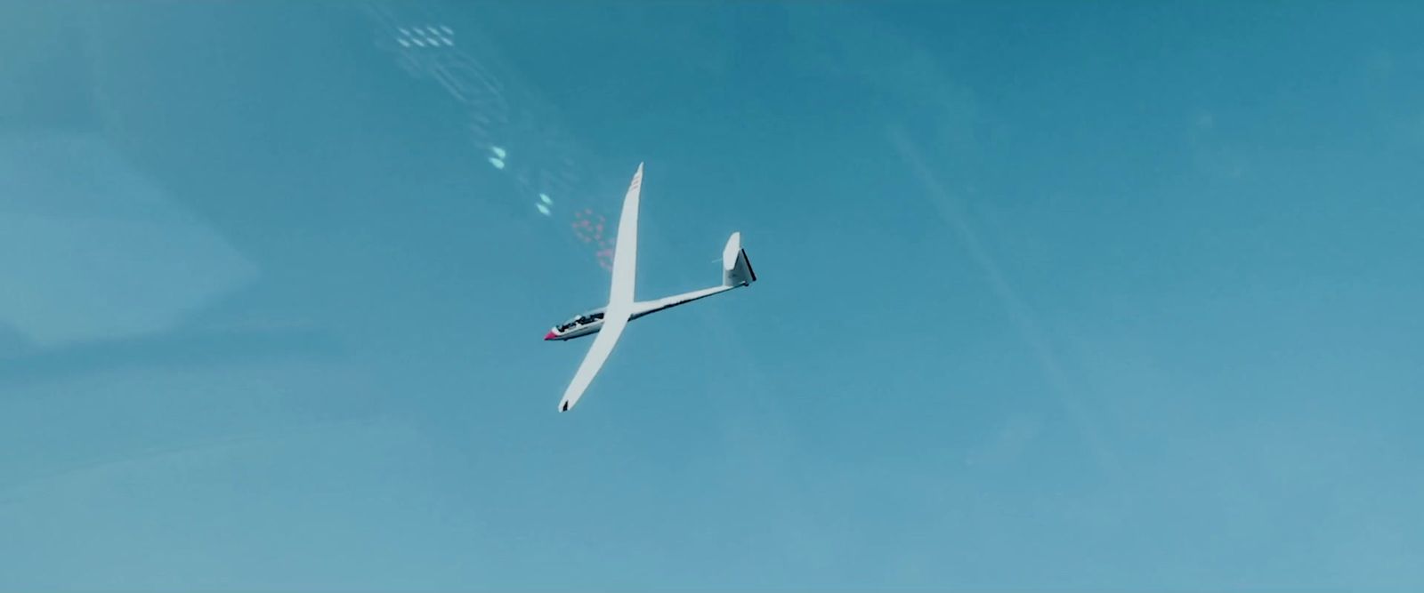 a plane flying through a blue sky with no clouds