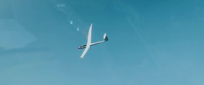 a plane flying through a blue sky with no clouds