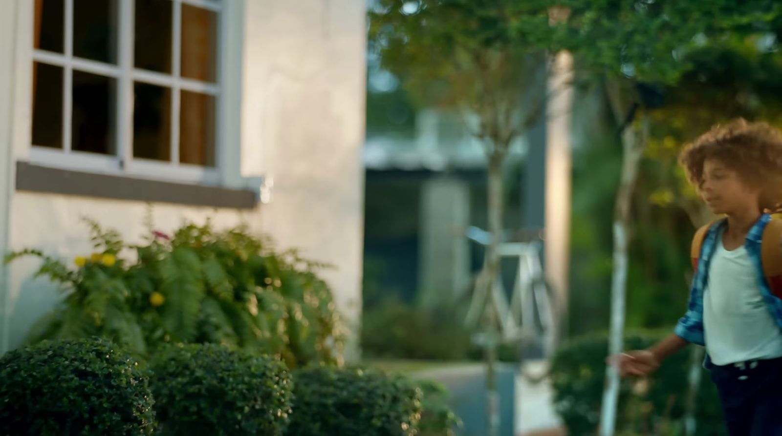 a boy with a backpack walking down the street