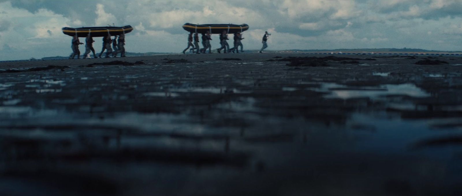 a group of people standing on top of a sandy beach