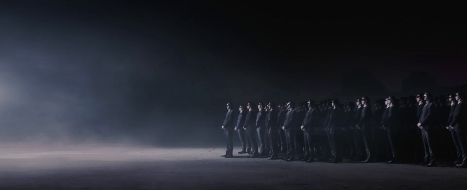 a group of people standing in a line in the dark