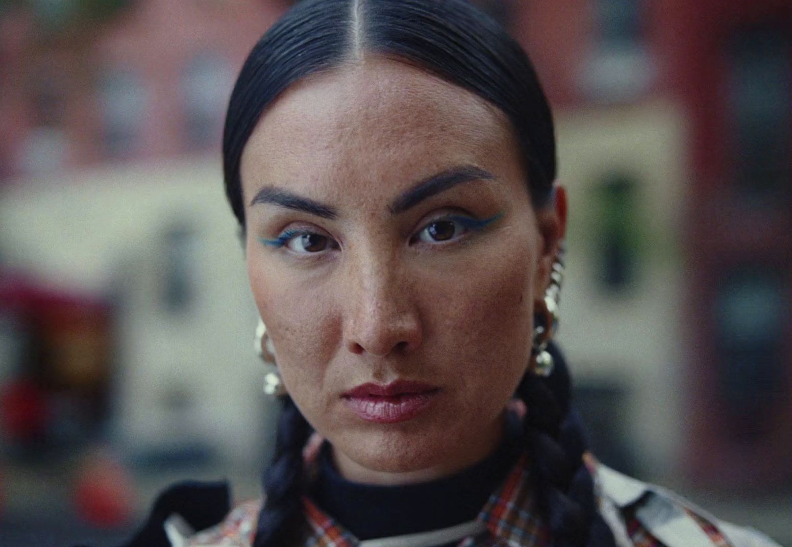 a close up of a person wearing a necklace and earrings