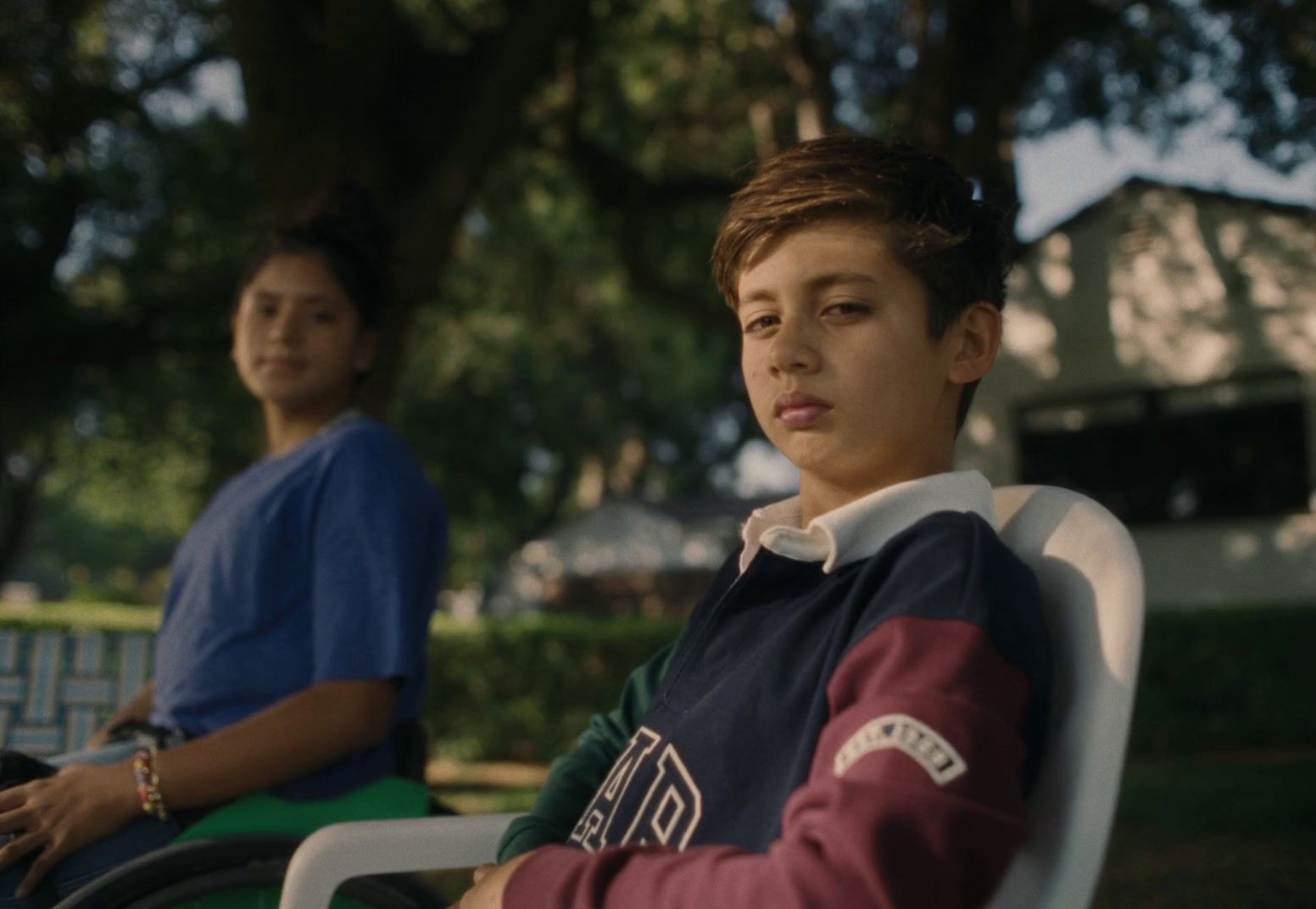 a boy sitting in a chair next to another boy