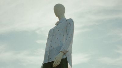 a mannequin is standing in front of a cloudy sky