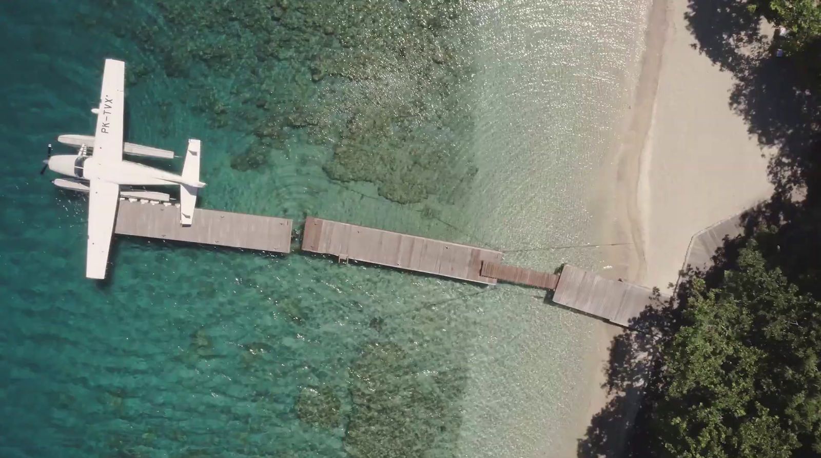 an airplane is flying over a pier in the water