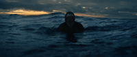 a person swimming in the ocean at night