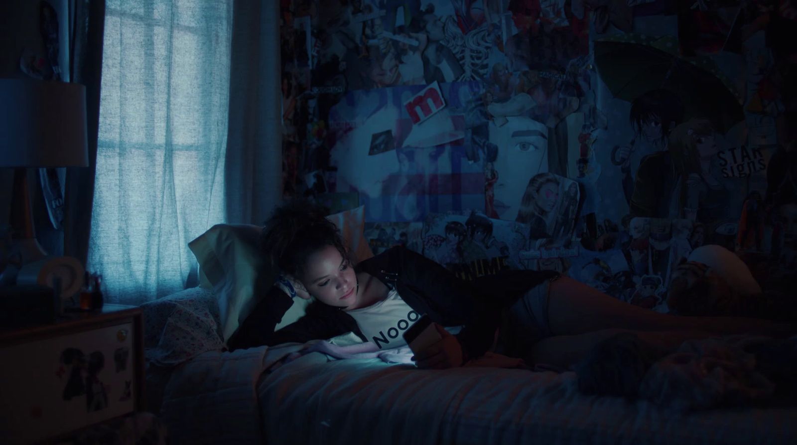 a woman laying on a bed in a dark room