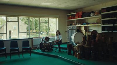 a woman is playing drums in a room