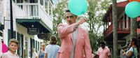 a man in a pink suit is holding balloons