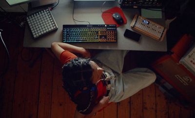 a person sitting at a desk with a keyboard and mouse