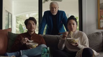 a group of people sitting on a couch eating food