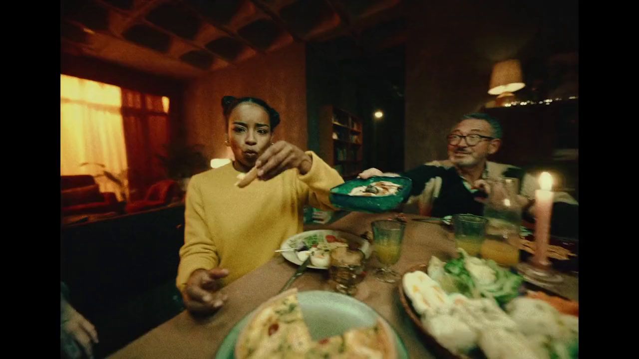 a man and a woman sitting at a table with food