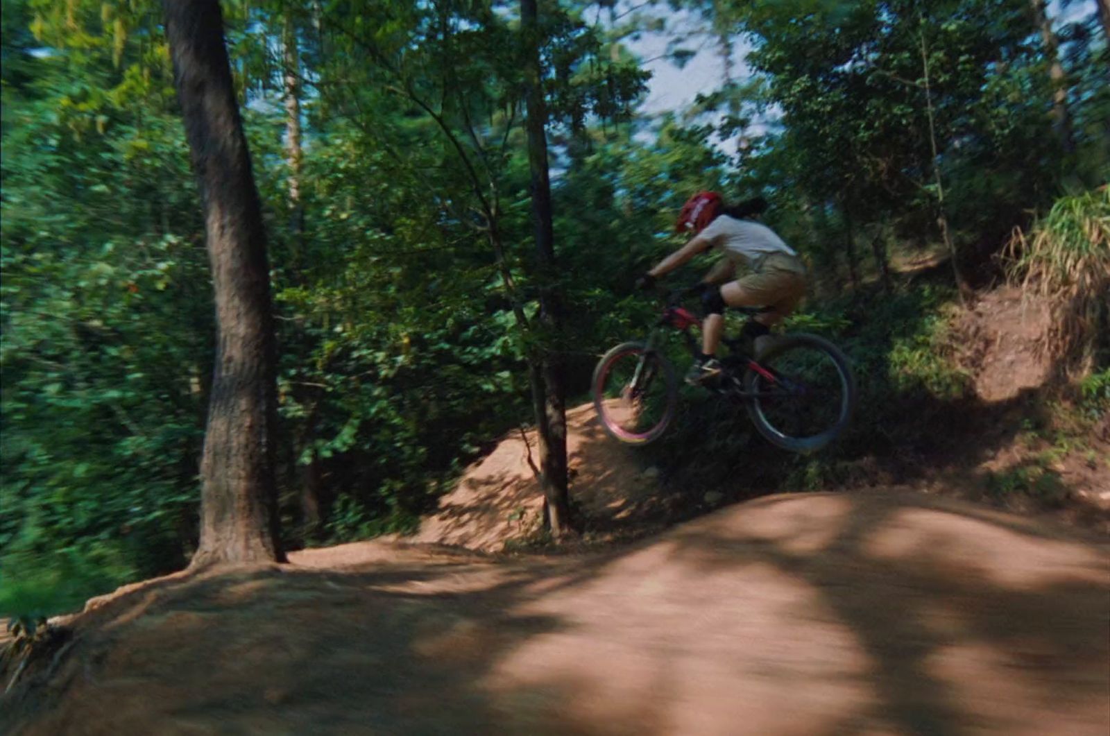 a man riding a bike down a dirt road