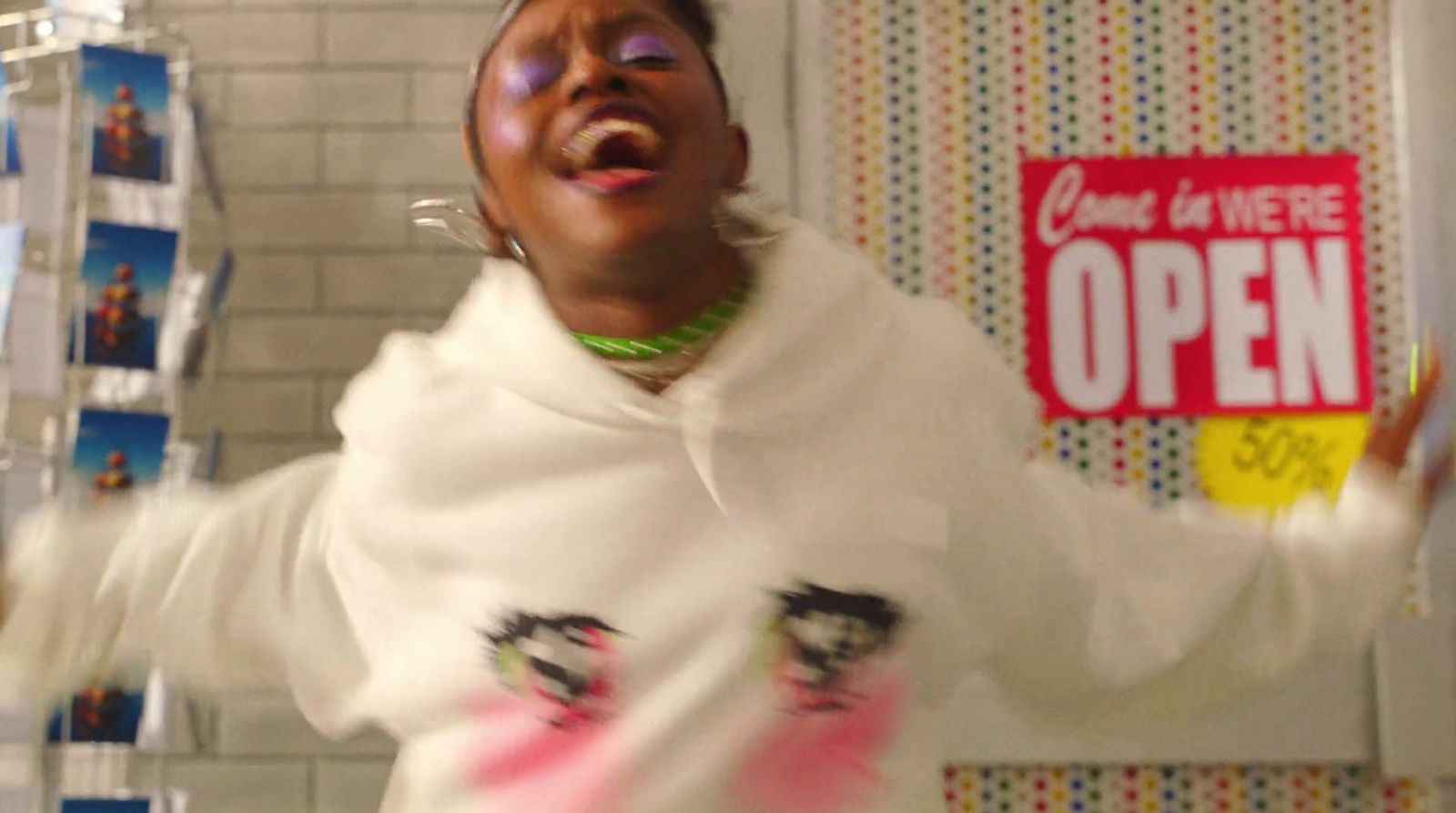 a woman in a white shirt is holding a cell phone