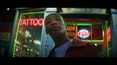 a man standing in front of a neon sign