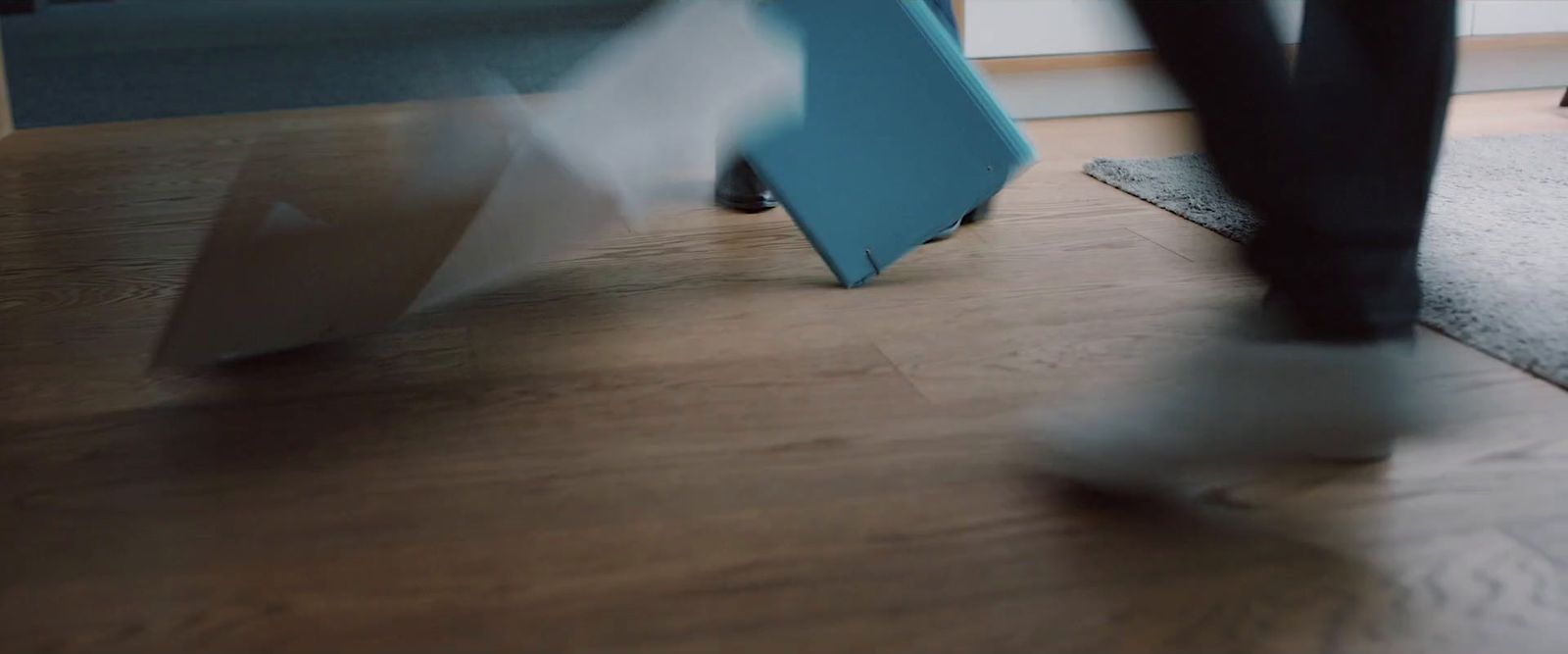 a blurry photo of a person walking on a wooden floor