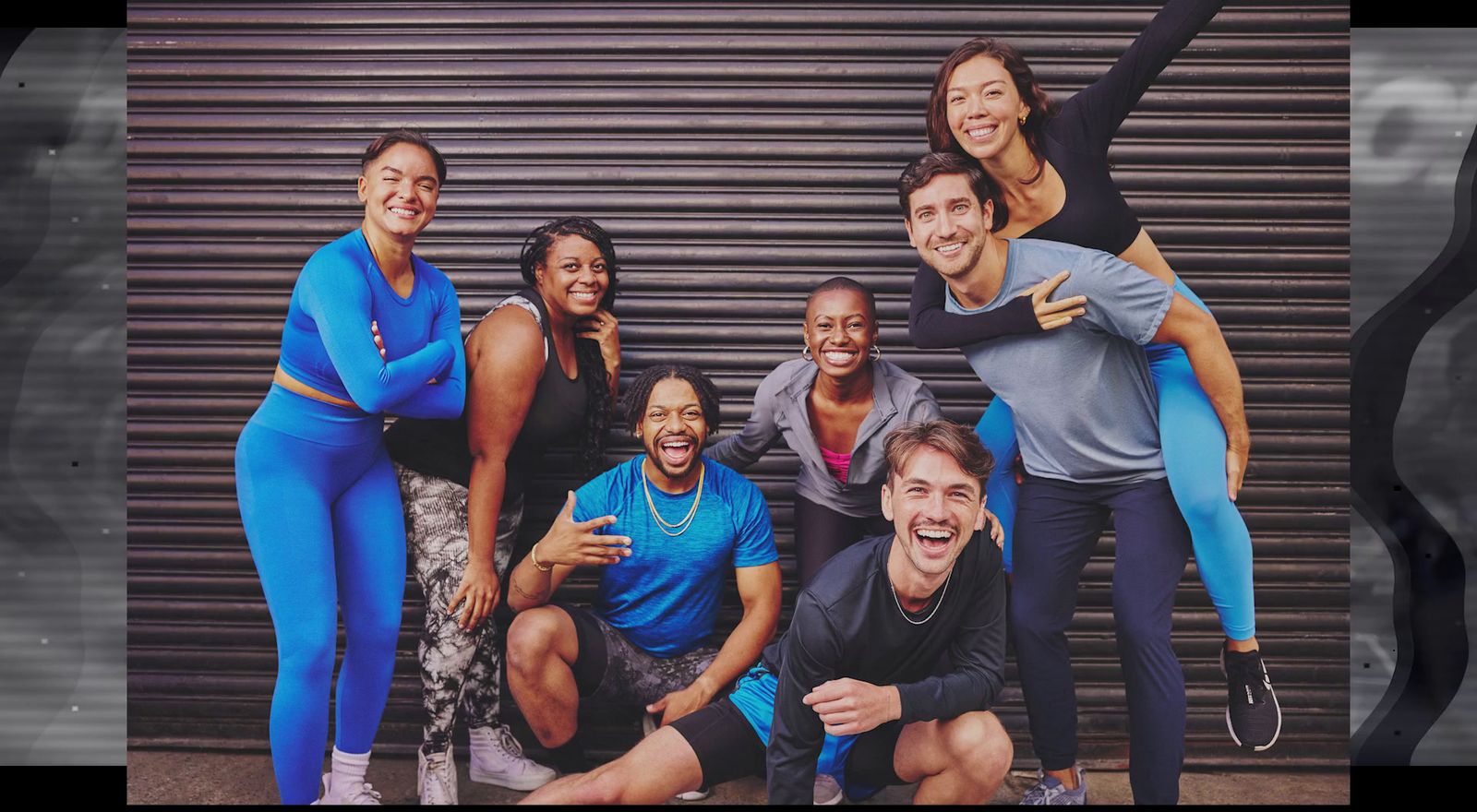 a group of people posing in front of a garage door