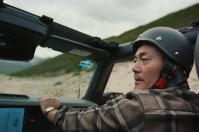 a man driving a truck down a dirt road