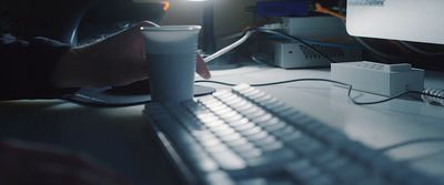 a person sitting at a desk with a computer and keyboard