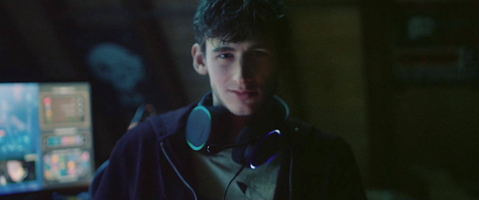 a young man wearing headphones in front of a computer