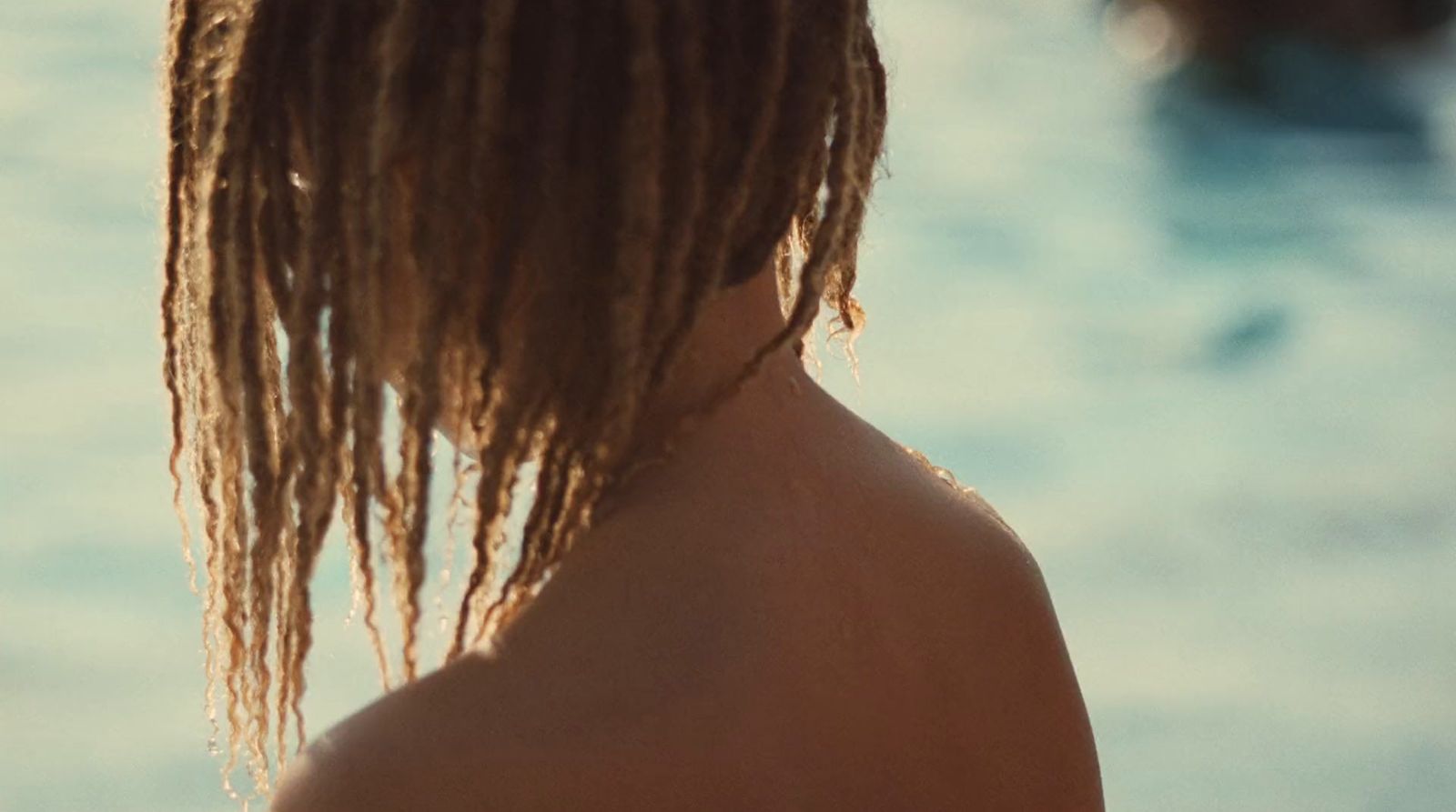 a woman with dreadlocks standing in the water