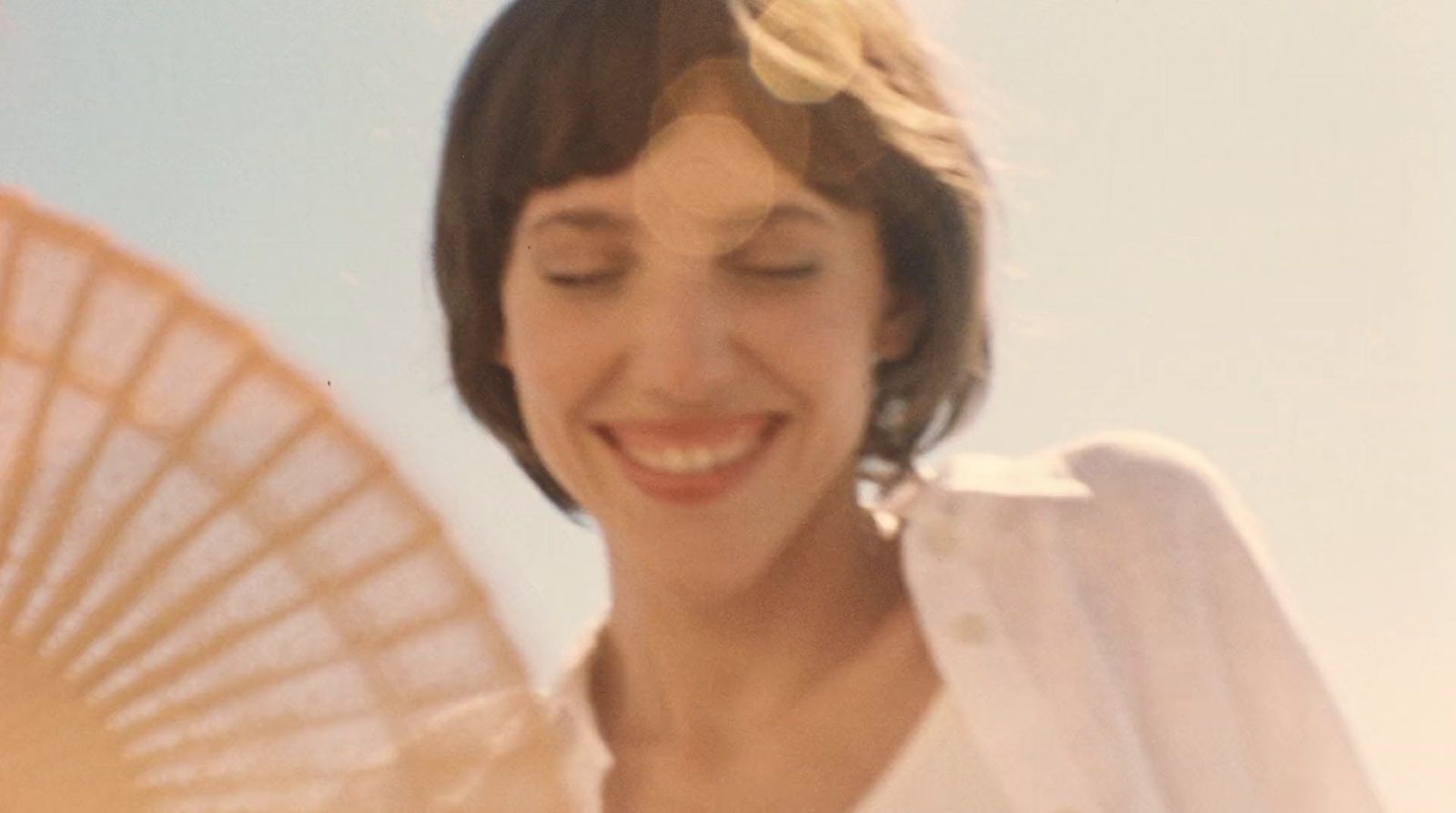 a woman smiles while holding a parasol