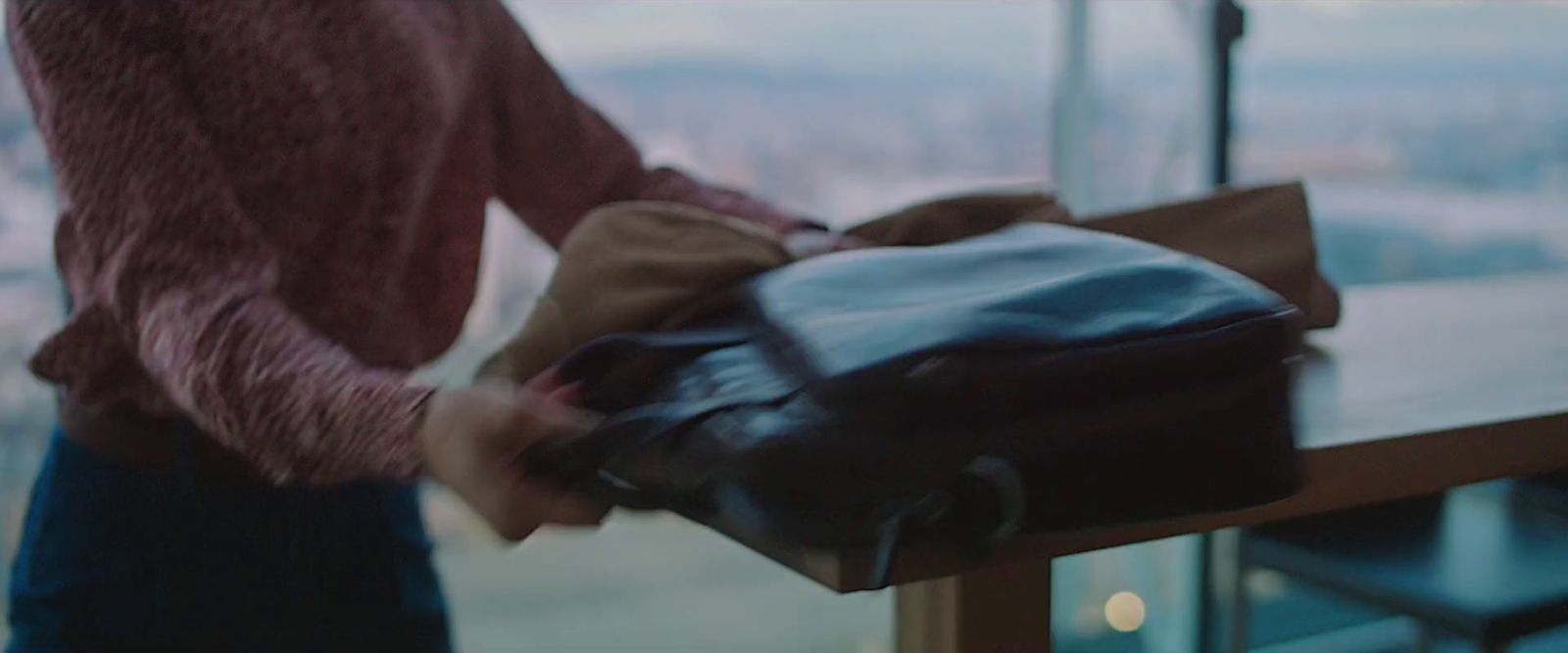 a person holding a brown bag near a window