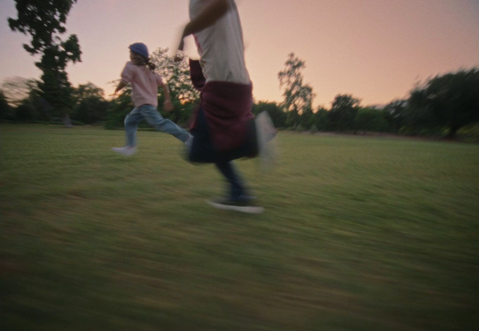 a couple of people that are running in the grass