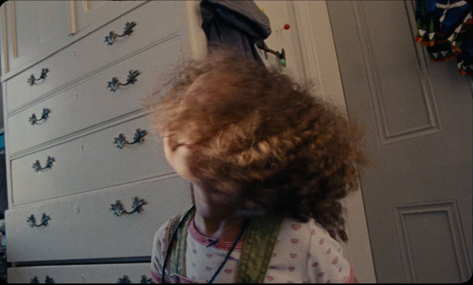 a little girl standing in front of a dresser