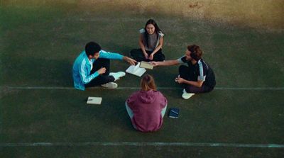 a group of people sitting on top of a tennis court